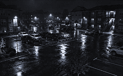Night camera view of an apartment complex parking lot