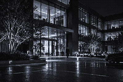 Night camera view of an office building entrance and plaza