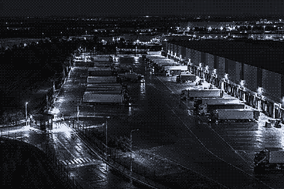 Night camera view of a logistics depot with parked trailers