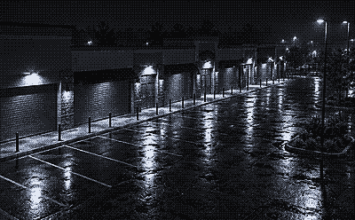 Night camera view of retail store fronts with lowered shutters